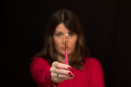 Woman shows the electronic cigarette on black background